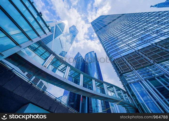 Looking up to high-rise office buildings, skyscrapers, architectures in financial district. Smart urban city for business and technology concept background in Downtown Hong Kong, China.