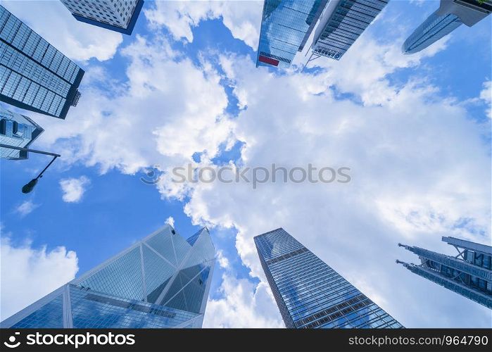 Looking up to high-rise office buildings, skyscrapers, architectures in financial district. Smart urban city for business and technology concept background in Downtown Hong Kong, China.