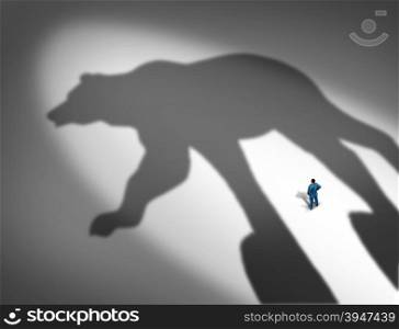 Looming financial crisis and slumping stock market business concept as a businessman standing in front of the cast shadow of a bear as a loss and price decline metaphor.