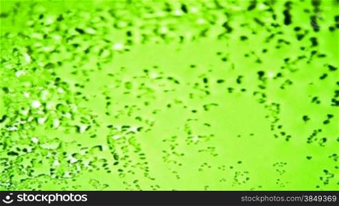 Loopable appearing water droplets (time lapse). Over lettuce green background