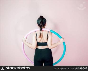 Lose belly fat concept from close up woman in sportswear and exercise with hula hoop for healthier body.