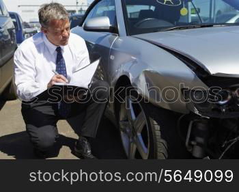 Loss Adjuster Inspecting Car Involved In Accident