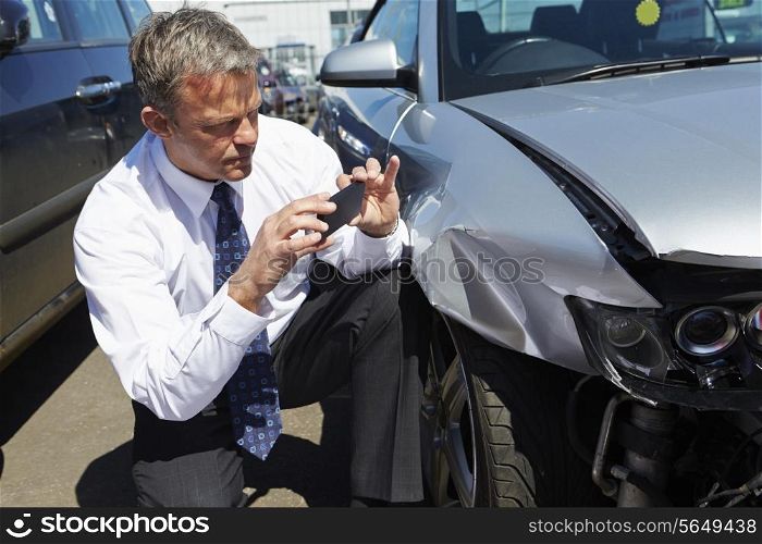 Loss Adjuster Inspecting Car Involved In Accident