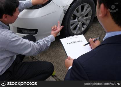 Loss Adjuster Insurance Agent Inspecting Damaged Car