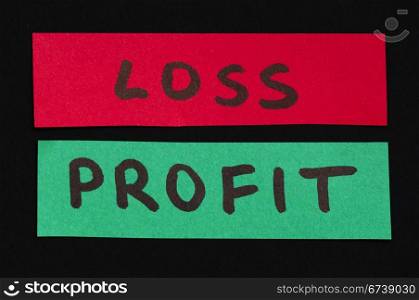 Loss and profit text over red and green paper