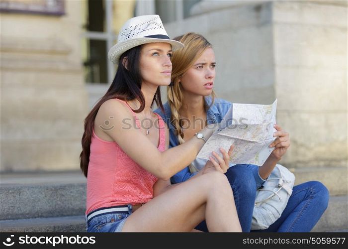 lost and confused girl friends looking for directions on map