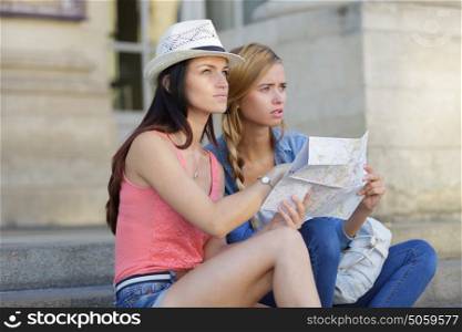 lost and confused girl friends looking for directions on map