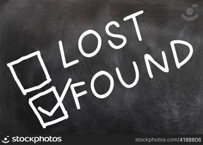 Lost and found check boxes with found checked, written with chalk on a blackboard