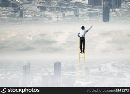 Lost between two worlds. Businessman standing on ladder between two urban realities