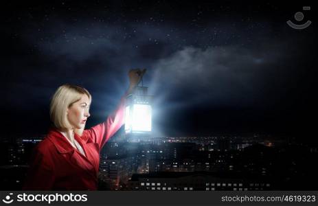 Lost in night. Young blond woman in red cloak with lantern