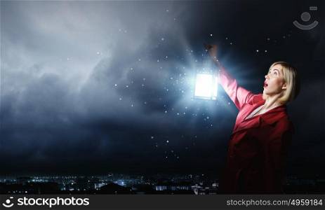Lost in night. Young scared woman in red cloak with lantern