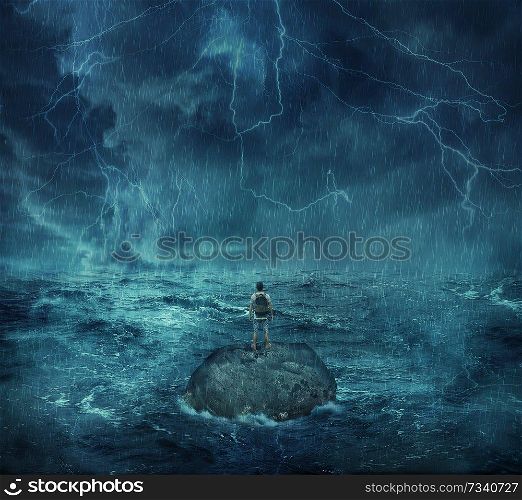 Lost man standing abandoned on a rock island in middle of the ocean, in a stormy night with lightnings in the sky. Looking for help, trying to survive. Adventure, journey and hard determination concept.