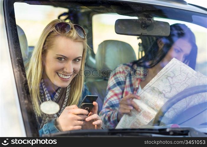 Lost with map two young friends in car enjoy road trip
