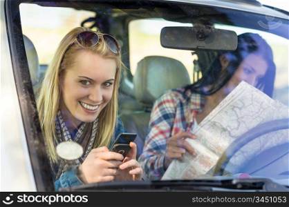 Lost with map two young friends in car enjoy road trip