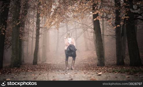 Lost woman foggy autumn park searching direction.. Lost confused woman in foggy fall autumn park searching direction. Fashion young girl holding jacket. Female looking for guidance in forest.