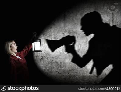 Lost woman. Young blonde in red cloak with lantern in darkness