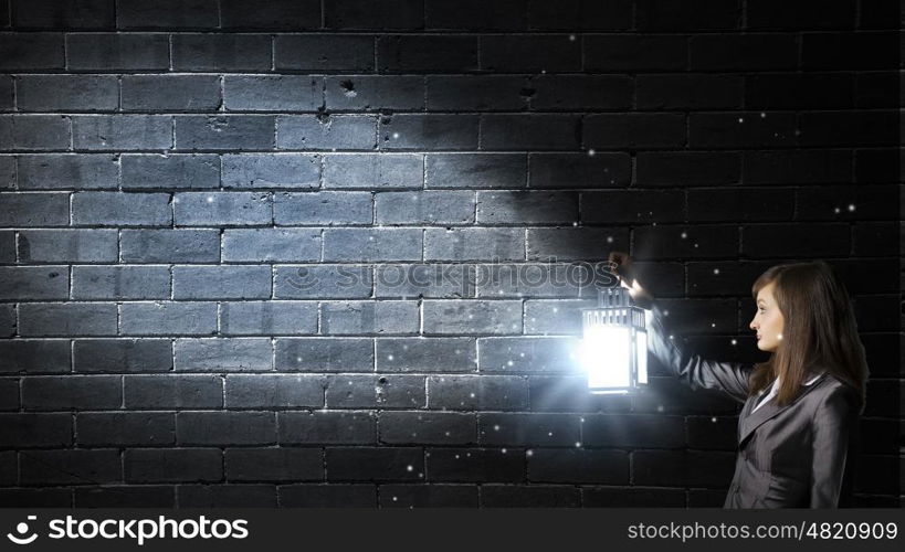 Lost woman. Young pretty businesswoman with lantern in darkness