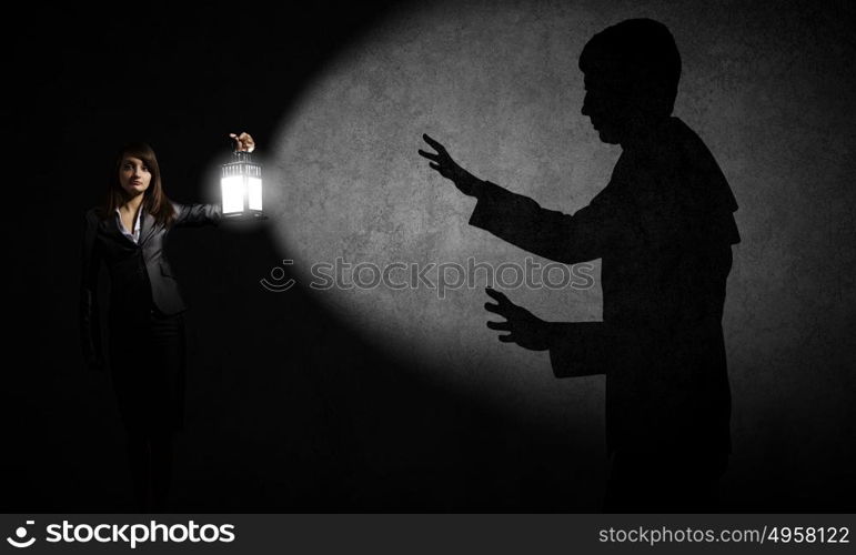 Lost woman. Young pretty businesswoman with lantern in darkness