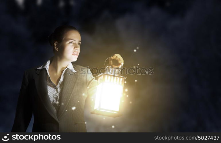 Lost woman. Young pretty businesswoman with lantern in darkness