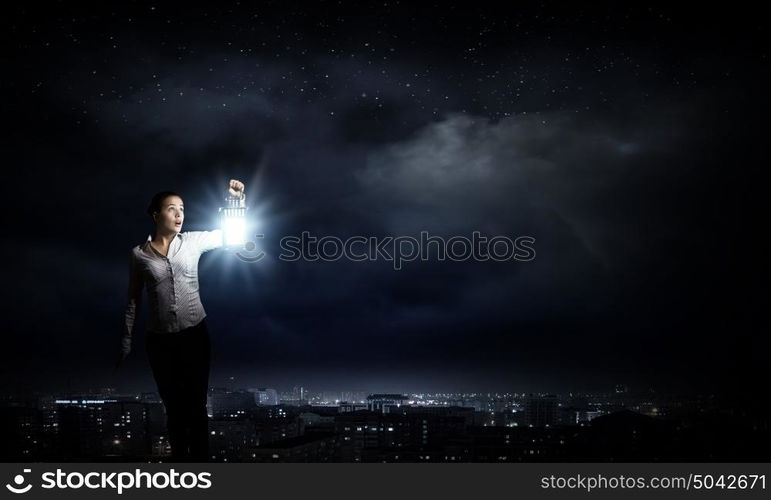 Lost woman. Young pretty businesswoman with lantern in darkness