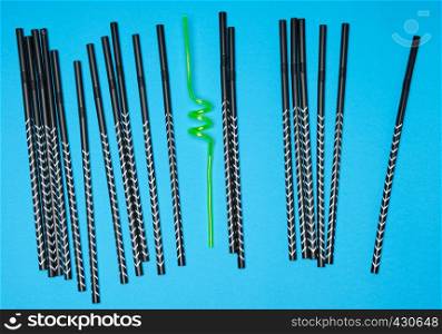 lot of black cocktail tubes and one yellow on a blue background