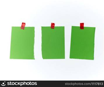 lot of torn green pieces of paper glued with scotch tape on a white background, place for text