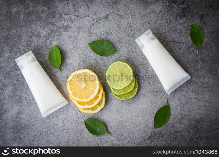 Lotion bottle natural for face and body beauty remedies and organic minimalist lifestyle with lemon lime slice and green leaves herbal formulations , top view