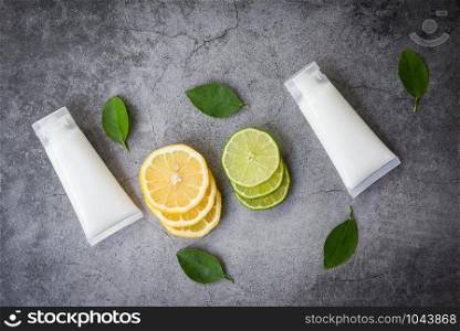 Lotion bottle natural for face and body beauty remedies and organic minimalist lifestyle with lemon lime slice and green leaves herbal formulations , top view