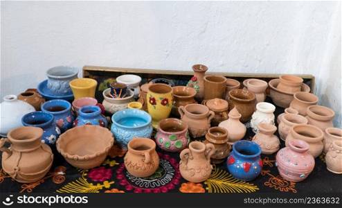 lots of beautifully decorated clay pots. children’s crafts. clay art pots