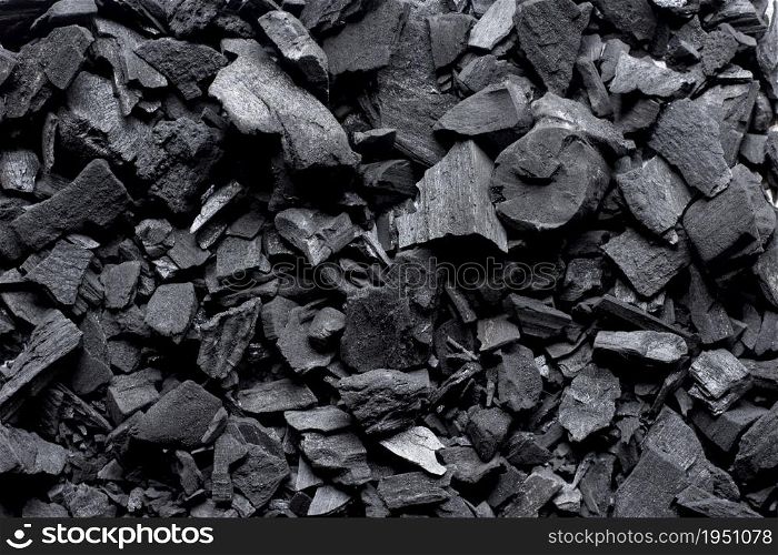 Lots of black charcoal piled up, black charcoal background.