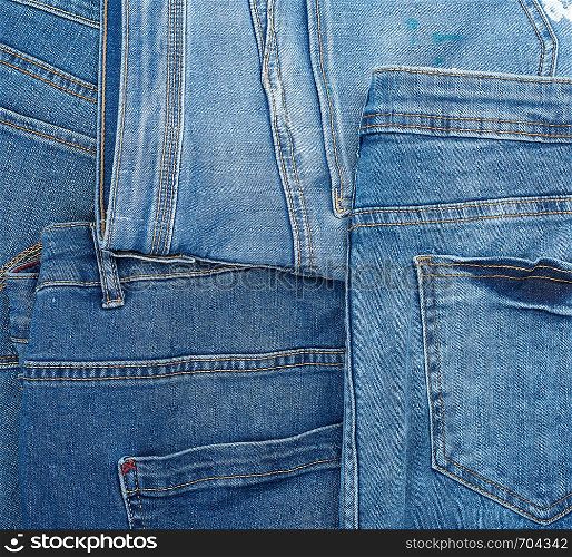 Lots of blue classic jeans stacked chaotically, back pocket, full frame