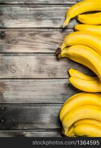 Lots of fresh aromatic bananas. On a black wooden background.. Lots of fresh aromatic bananas.
