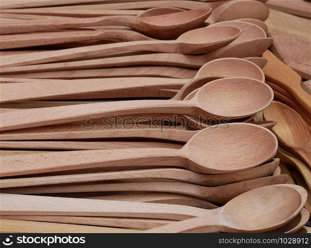 Lots of fresh handmade carved wooden spoons on marketplace for sale, close-up