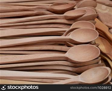Lots of fresh handmade carved wooden spoons on marketplace for sale, close-up