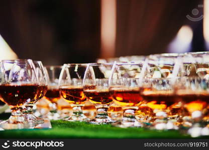 lots of glasses of whiskey. glasses of whiskey or brandy. alcohol. selective focus.