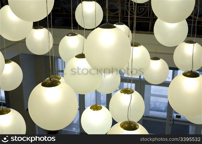 lots of round lamps hanging on long cords at various height