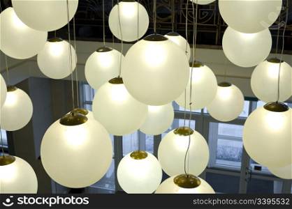 lots of round lamps hanging on long cords at various height