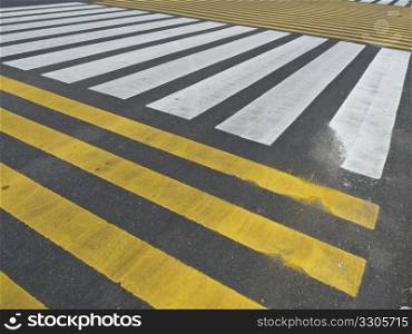 lots of stripes on the asphalt indicating a crossing of pedestrians
