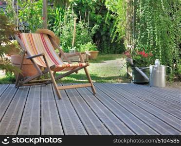 lounge chair on wooden terrace in a home garden