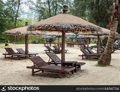 Lounge chairs and a sunshade umbrella on the tropical beach