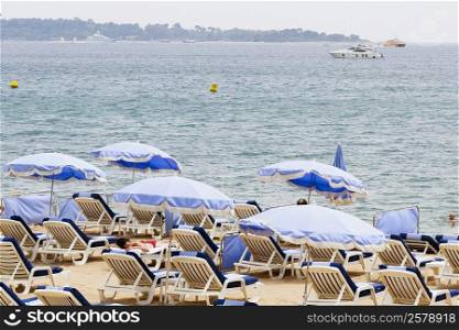 Lounge chairs and beach umbrellas on the beach, Plage De La Croisette, Cote d&acute;Azur, Cannes, Provence-Alpes-Cote D&acute;Azur, France