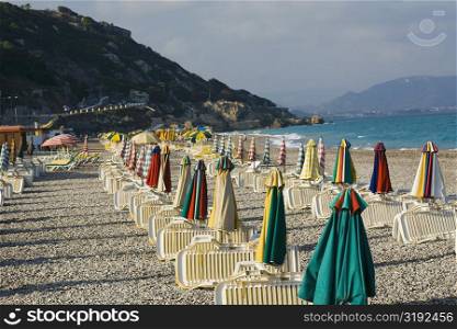 Lounge chairs and beach umbrellas on the beach, Rhodes, Dodecanese Islands, Greece