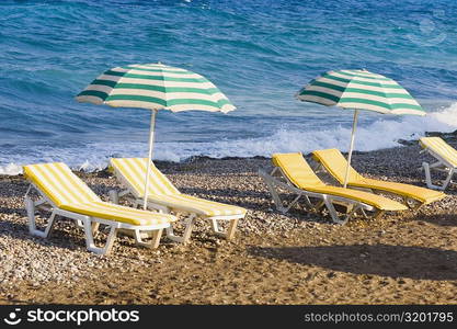 Lounge chairs and beach umbrellas on the beach, Rhodes, Dodecanese Islands, Greece