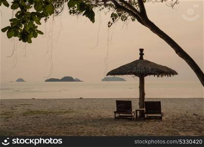 Lounge chairs and sunshade umbrella on the beach. Lounge chairs and a sunshade umbrella on the tropical beach