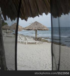 Lounge chairs with sunshades on the beach, Utopia Village, Utila Island, Bay Islands, Honduras