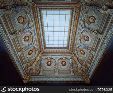 Louvre Palais ornate ceiling with glass window in center. Angels sculptures with golden decorations