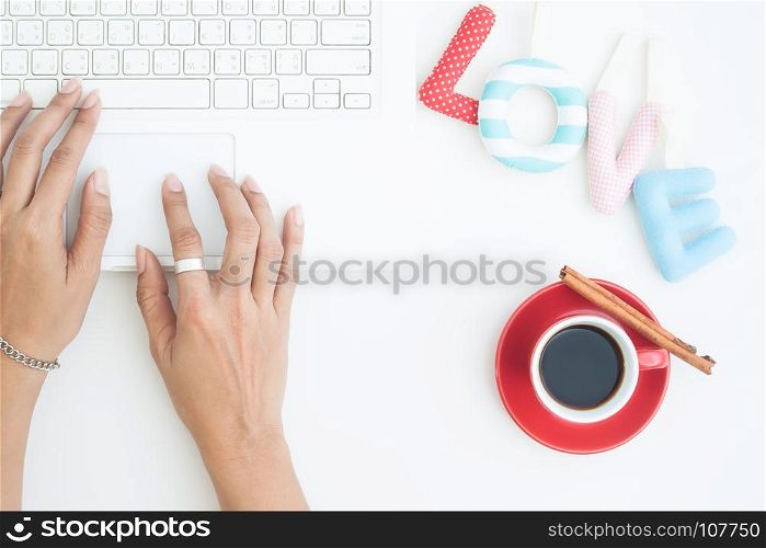 Love alphabets on white background with woman hands working on laptop, Top view love concept