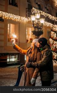 Love among the Christmas lights.. A large portrait of a couple in love against the background of the New Yea