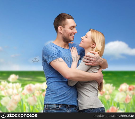 love and family concept - smiling couple hugging and looking at each other