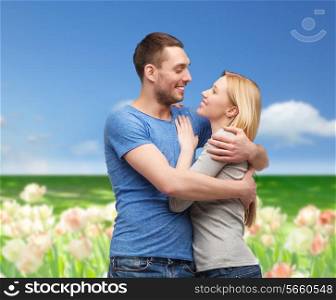 love and family concept - smiling couple hugging and looking at each other